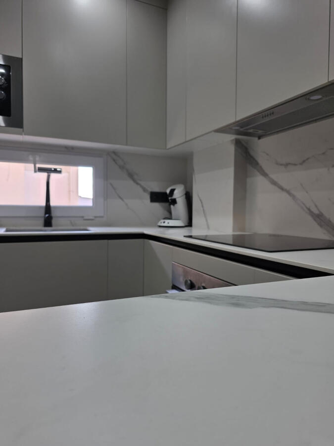 Cocina blanca a medida en Granada cocina con porcelánico blanco