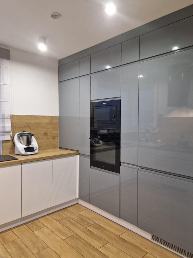 Cocina gris brillante y madera en Granada Cocina con electrodomésticos integrados